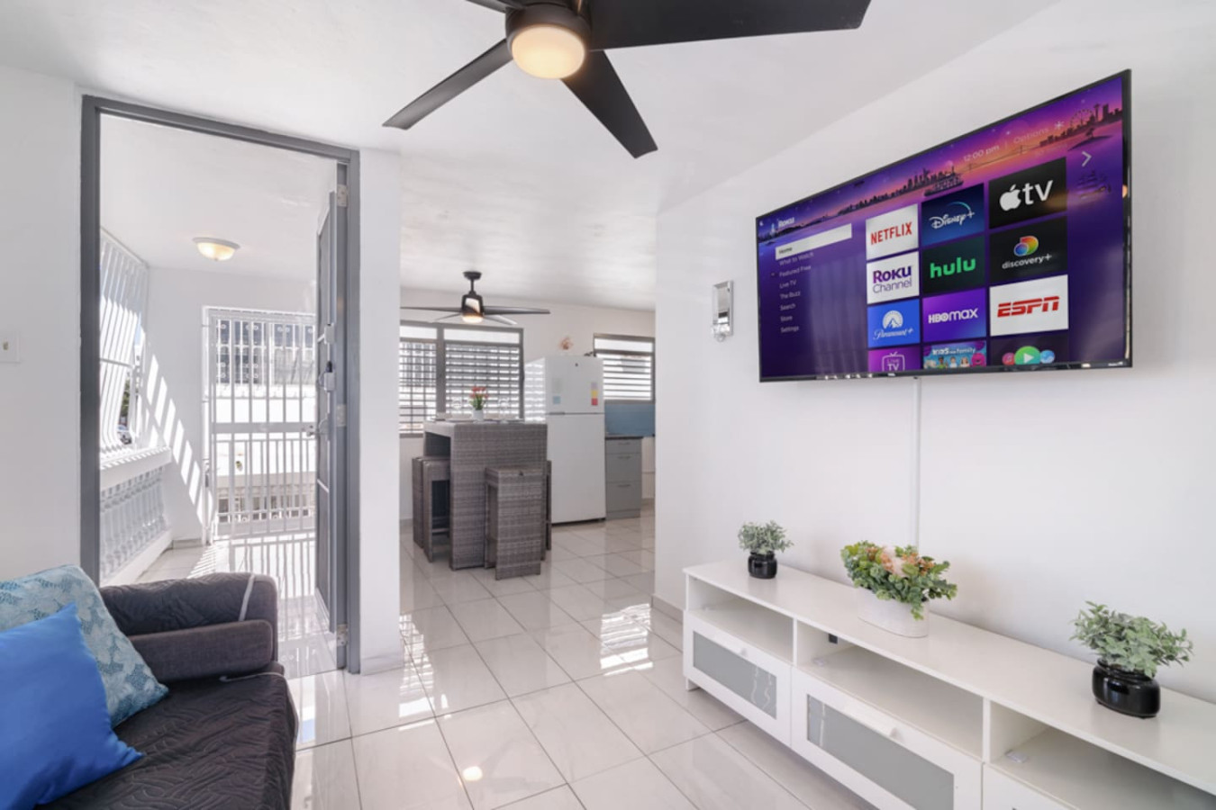 Living room with a flat screen TV and a potted plant — Casa Juno Grand Modern - 3 Bedroom - Walk to Beach, Santurce