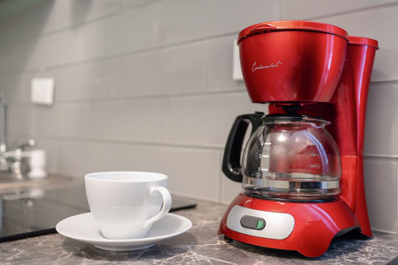 Red coffee maker on a counter next to a white cup — Casa Juno I: Private Courtyard Studio, Santurce