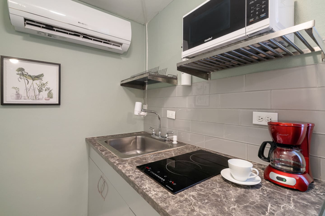 Kitchen with a sink, stove, and microwave — Casa Juno I: Private Courtyard Studio, Santurce