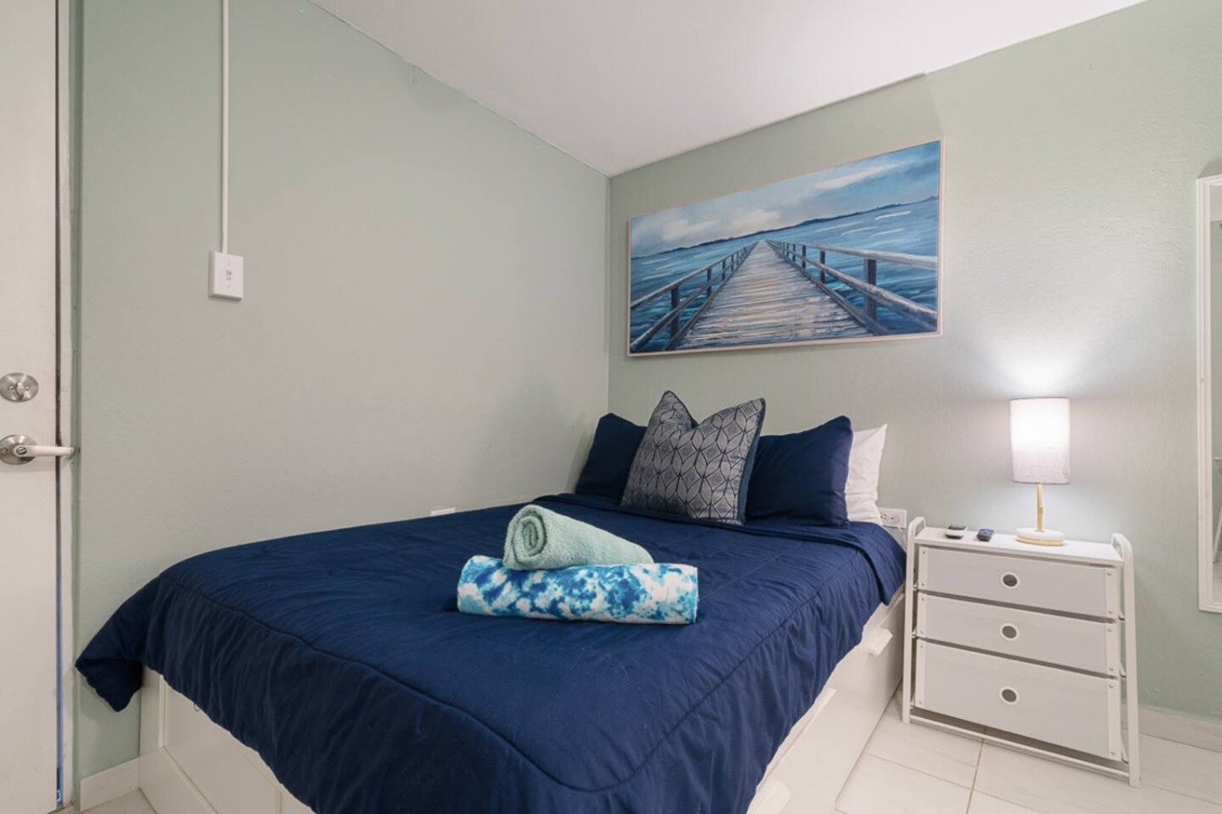 Bedroom with a blue bedspread and a painting on the wall (bedroom 2) — Casa Juno I: Private Courtyard Studio, Santurce