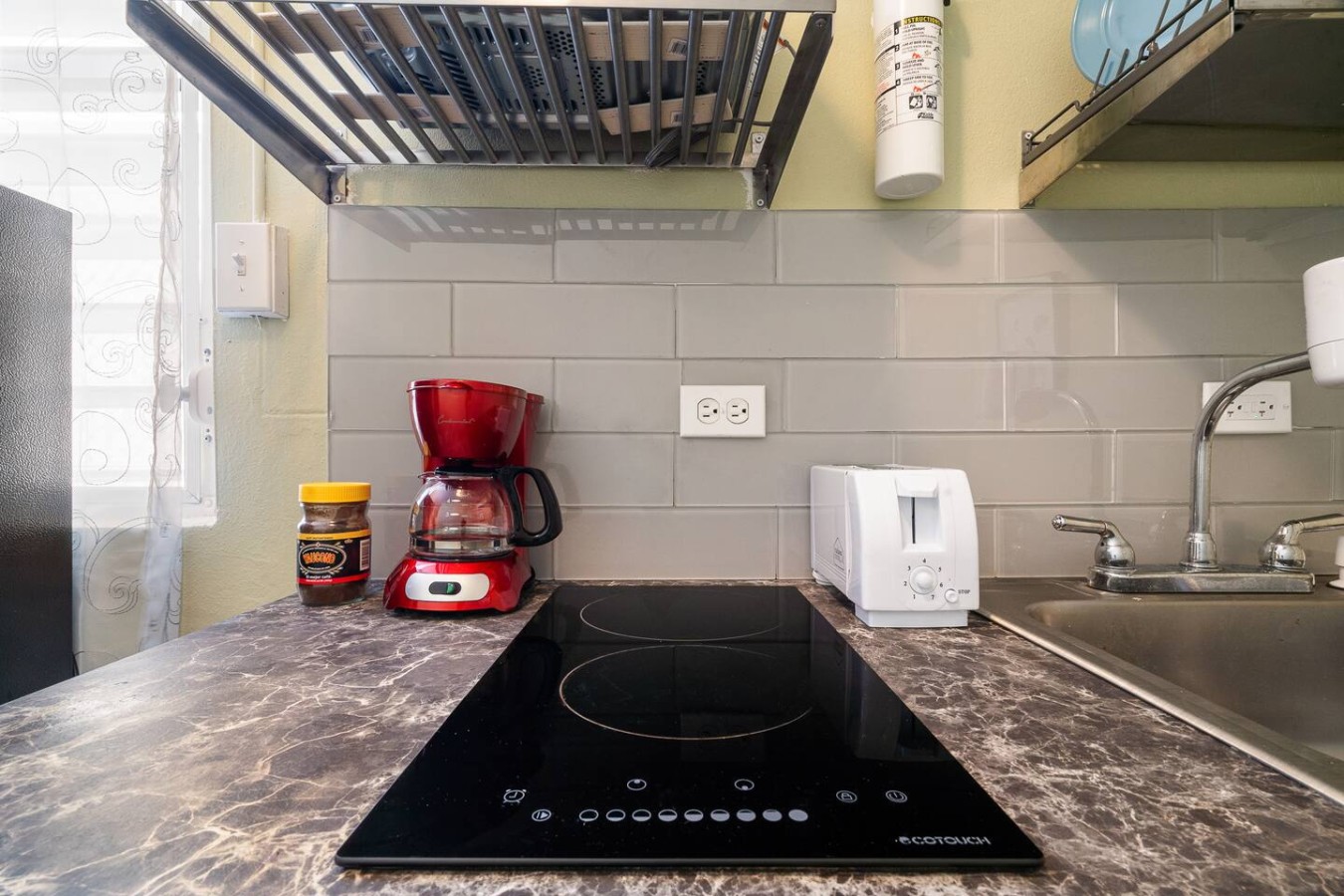 Kitchen with a red coffee maker and a black stove top oven — Romero Studio San juan near beach, Santurce