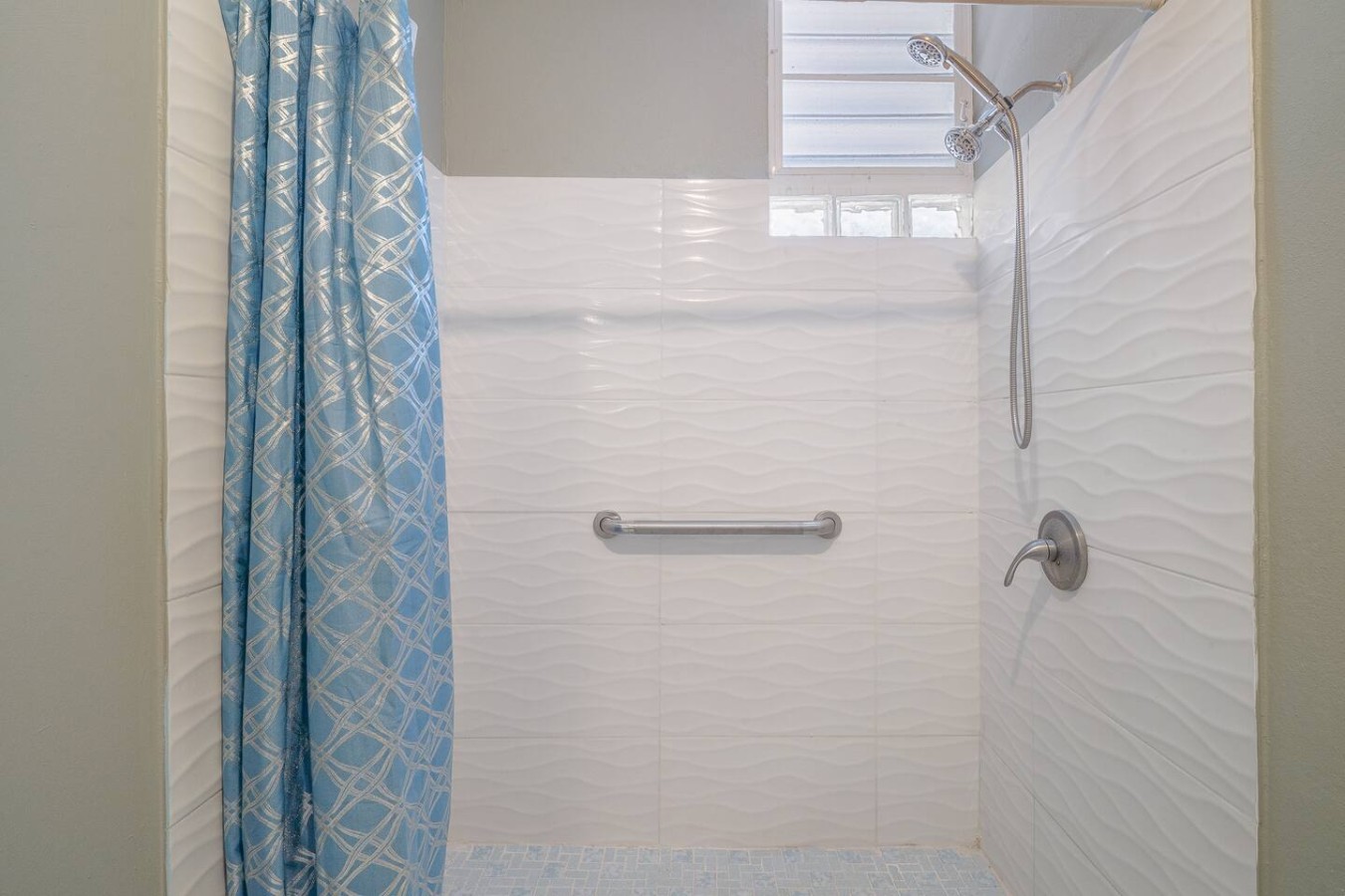 White tiled bathroom with a shower and a towel rack — Romero Studio San juan near beach, Santurce