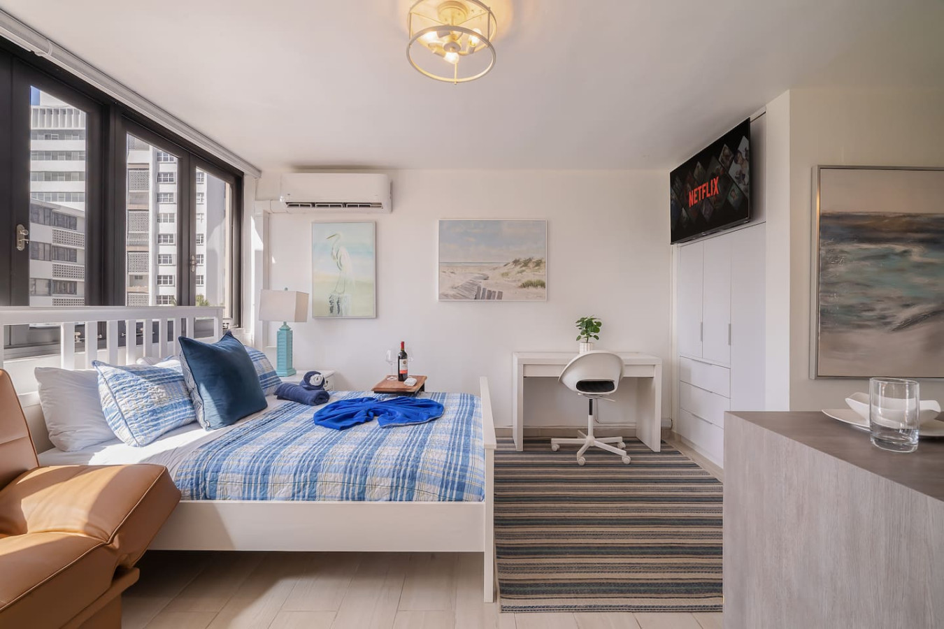 Bedroom with a blue bedspread and a painting on the wall — Luxe Beachside Oasis: Pool Parking & Generator, Santurce