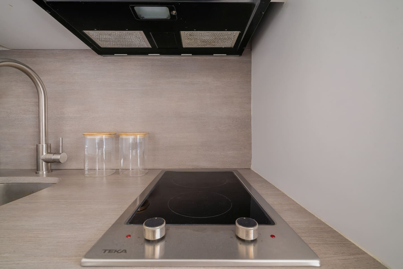 Kitchen with a stove top oven and two glasses on the counter — Luxe Beachside Oasis: Pool Parking & Generator, Santurce