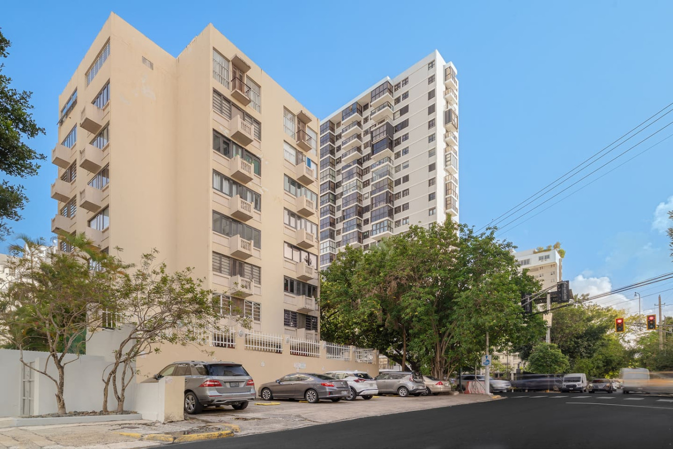 Building on a street corner with parked cars — Luxe Beachside Oasis: Pool Parking & Generator, Santurce