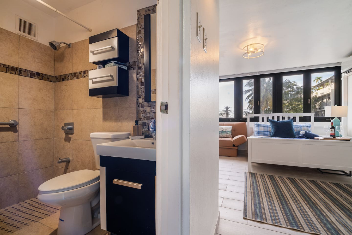 Bathroom with a toilet, sink, and blue cabinet — Luxe Beachside Oasis: Pool Parking & Generator, Santurce