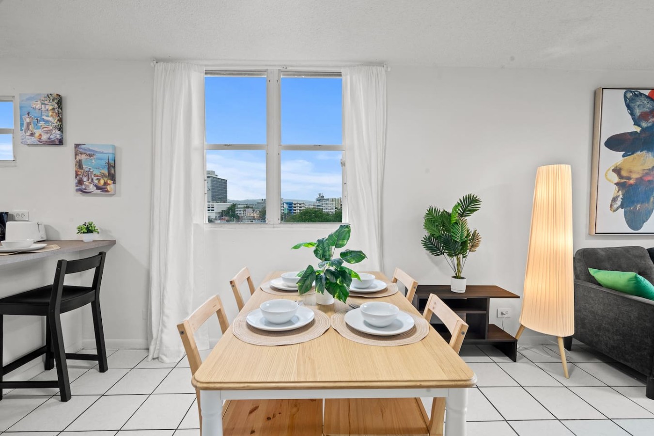 Dining room table with chairs and a view of the city — High-Rise Condado Suite | Ocean Views & PR Skyline, Condado