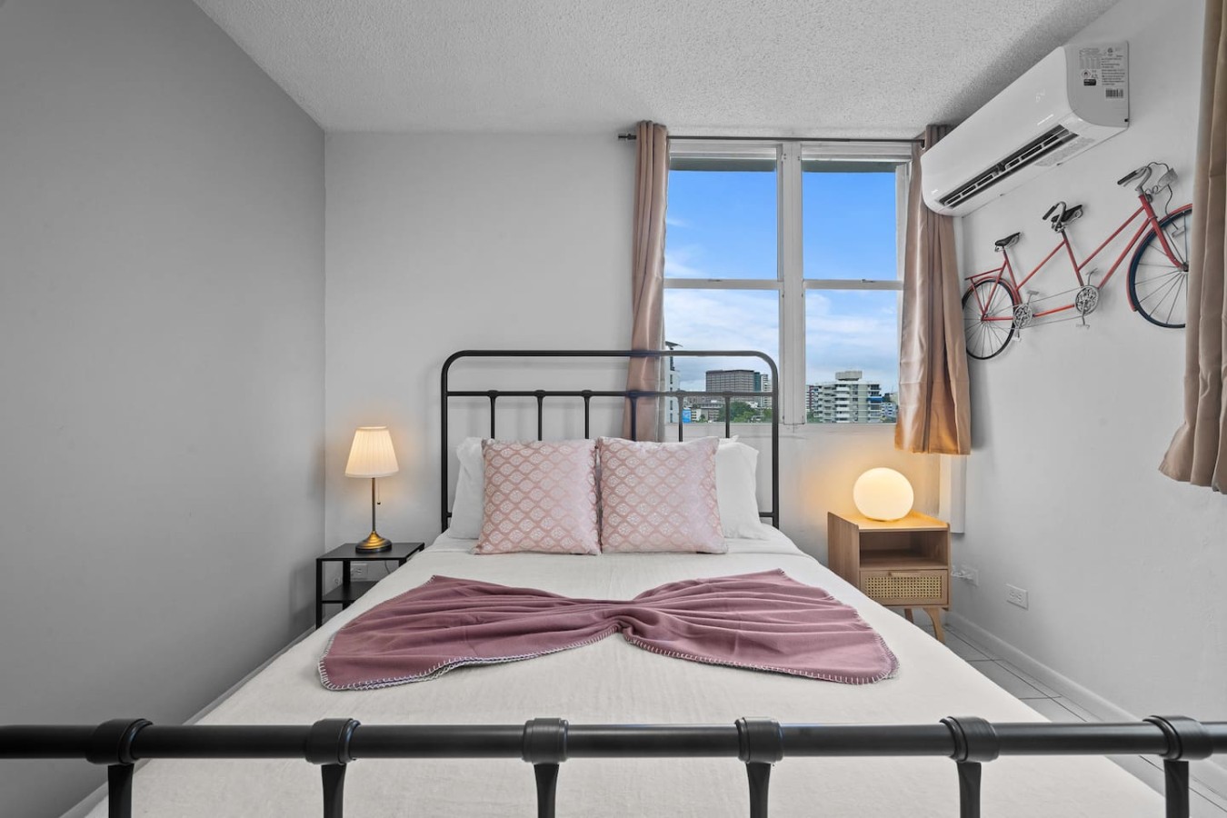 Bedroom with a large bed and a view of the city — High-Rise Condado Suite | Ocean Views & PR Skyline, Condado