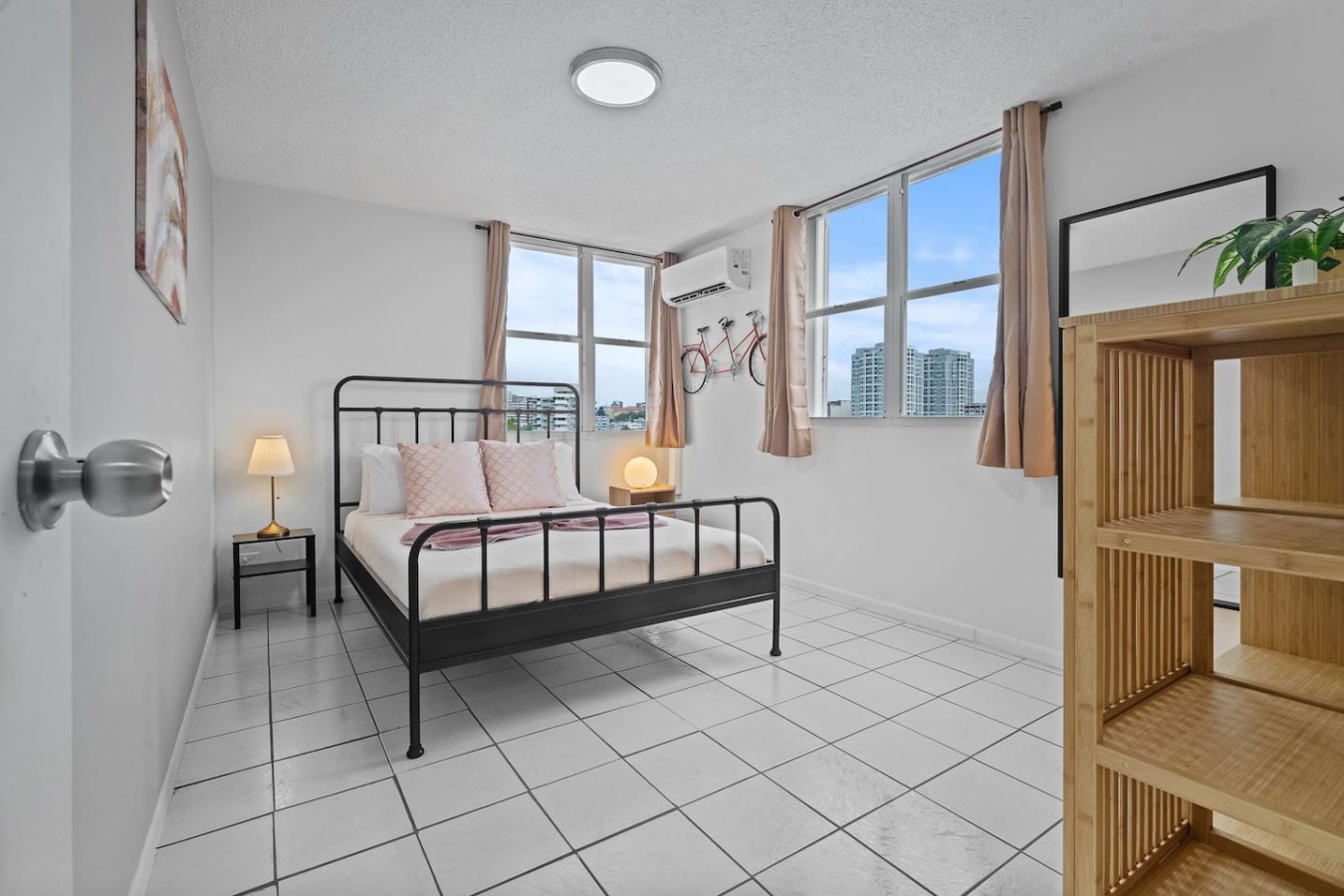 Bedroom with a black metal bed and a white tile floor — High-Rise Condado Suite | Ocean Views & PR Skyline, Condado