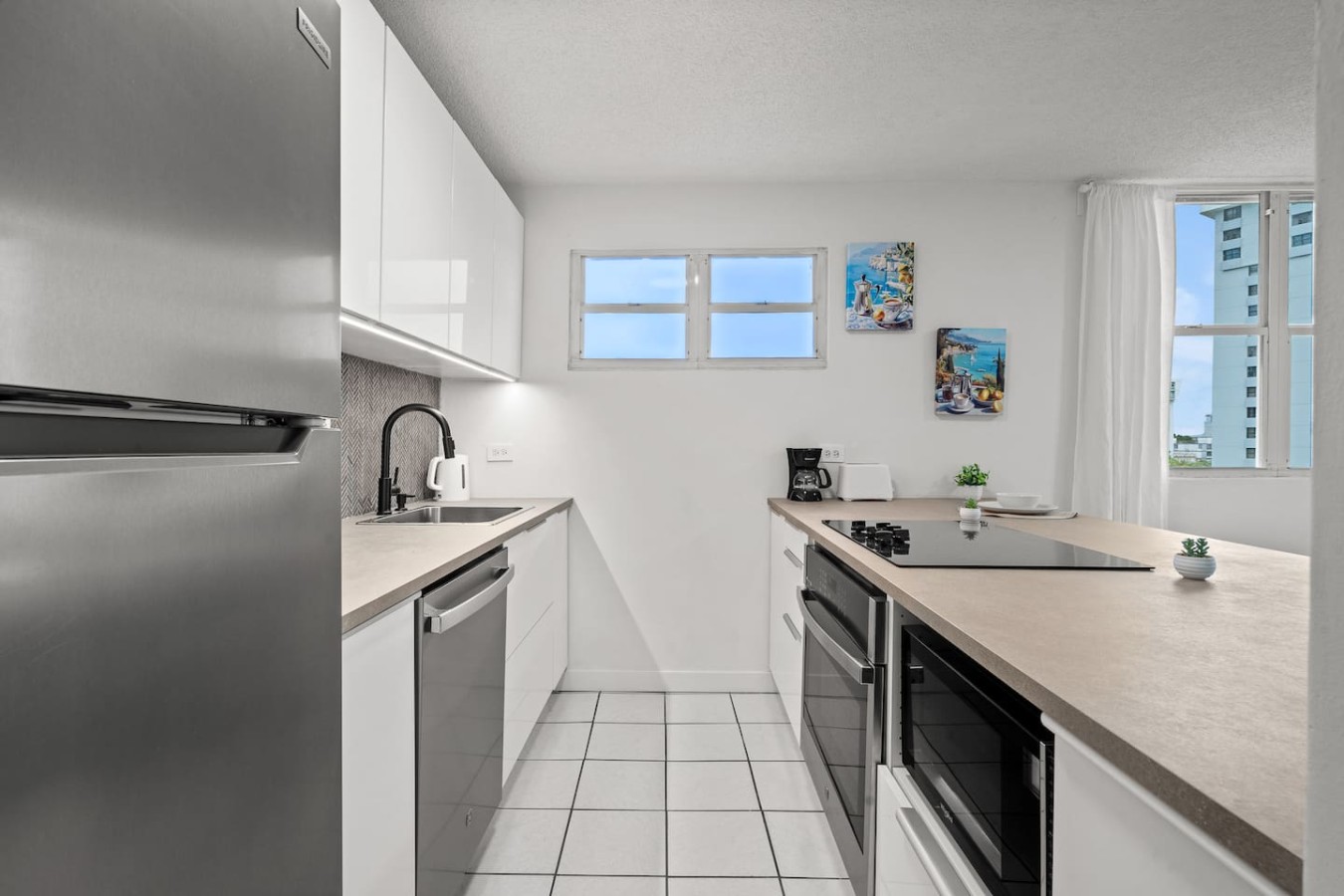 Kitchen with a refrigerator, sink, and oven — High-Rise Condado Suite | Ocean Views & PR Skyline