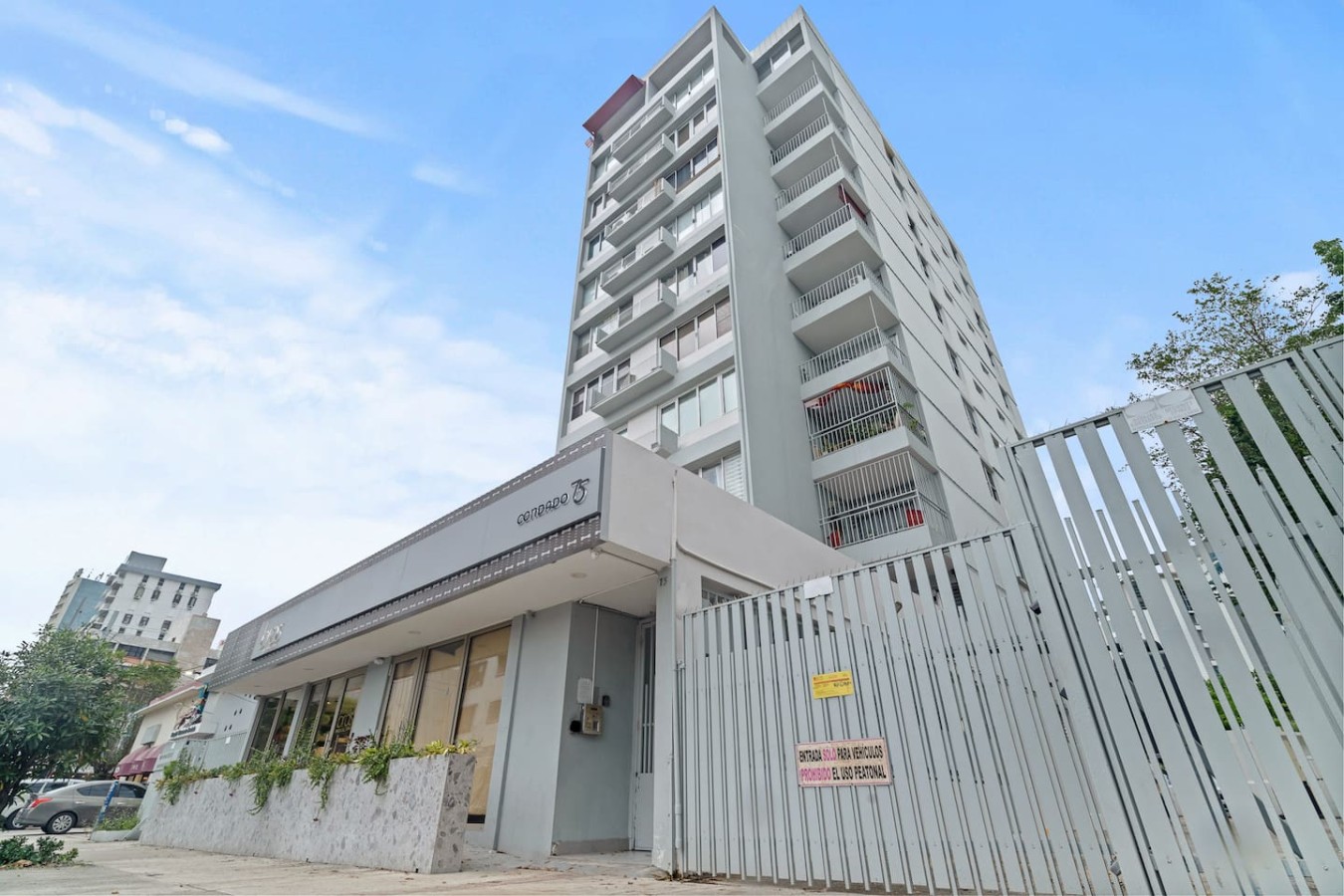Exterior of the high-rise building and its fenced entrance — High-Rise Condado Suite | Ocean Views & PR Skyline