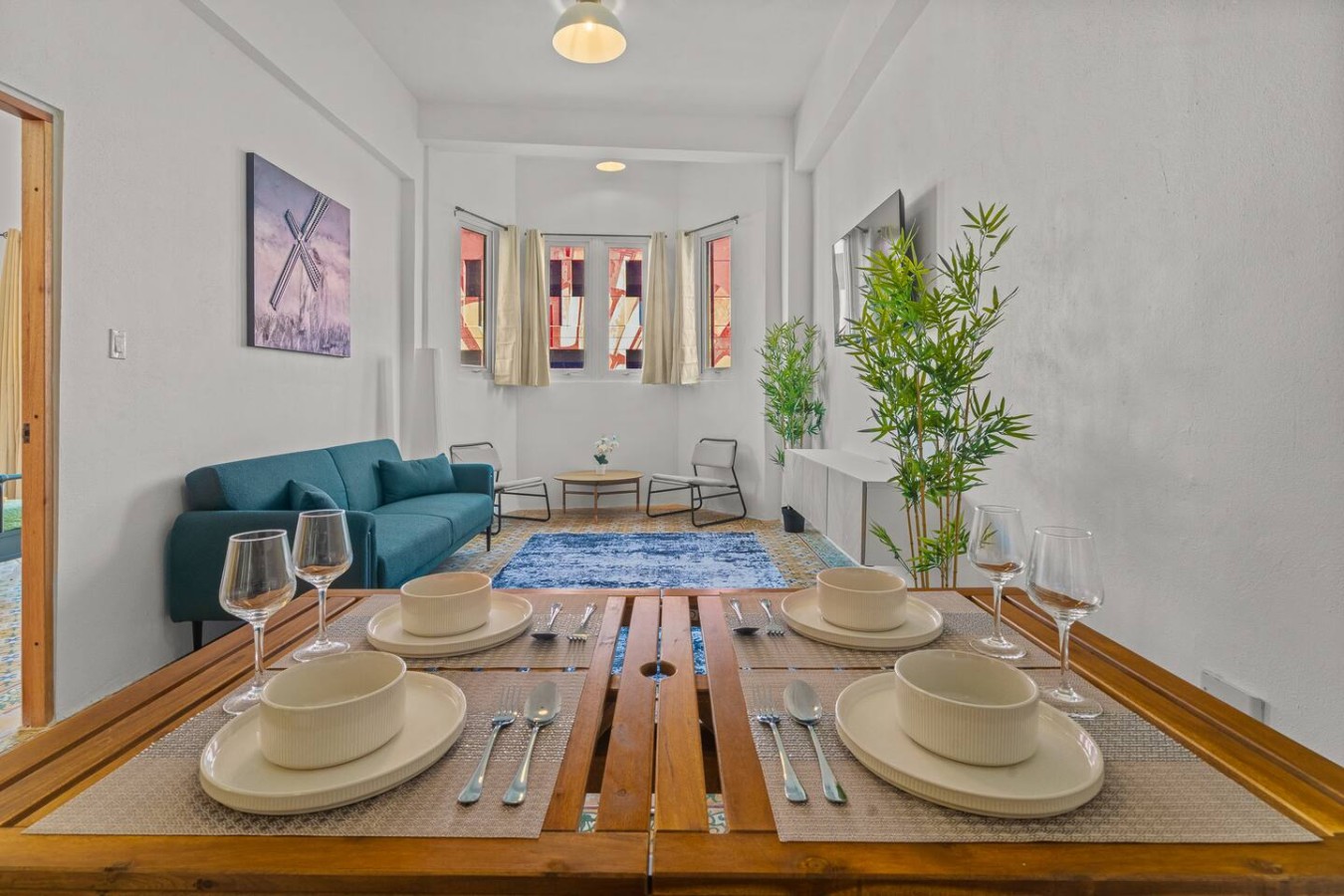 Dining table with blue chairs and a blue couch in the — The Galleria House | Private Patio Old San Juan, Old San Juan