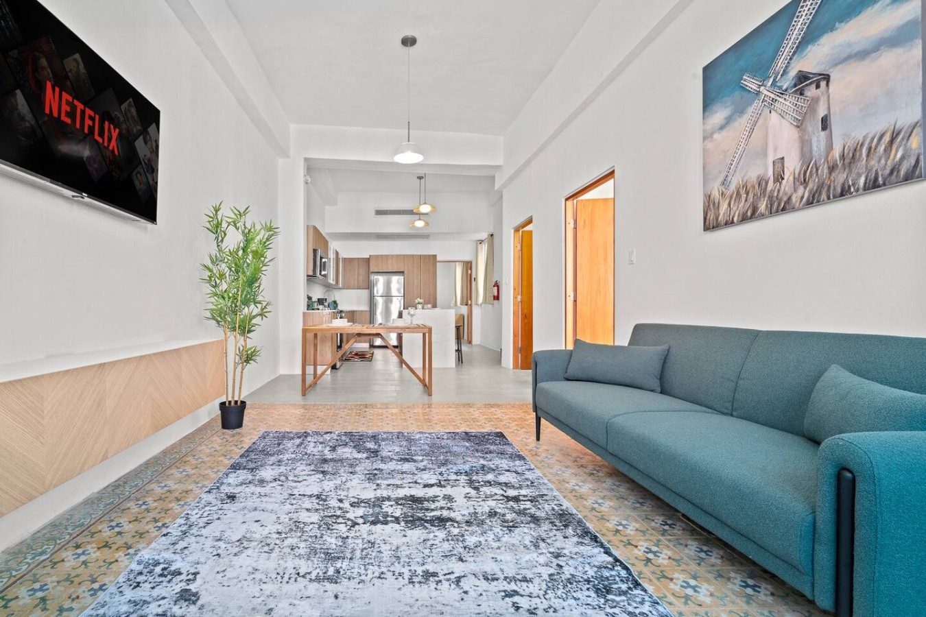 Living room with a blue couch and a potted plant in the — The Galleria House | Private Patio Old San Juan, Old San Juan