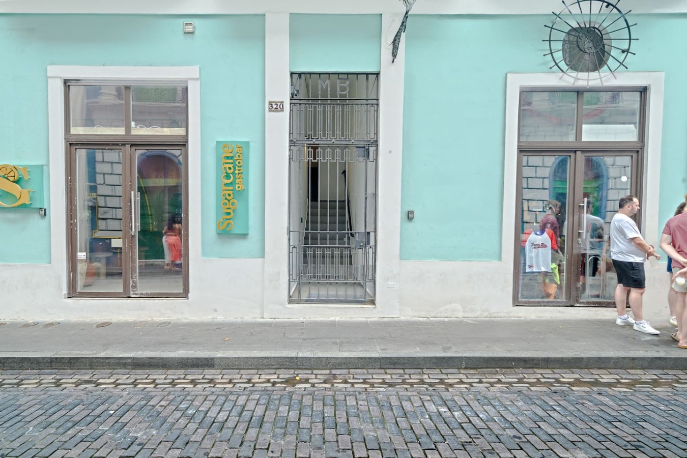 Blue and white building with a green sign on the side of it — Bellavista Galleria | Old San Juan, Old San Juan