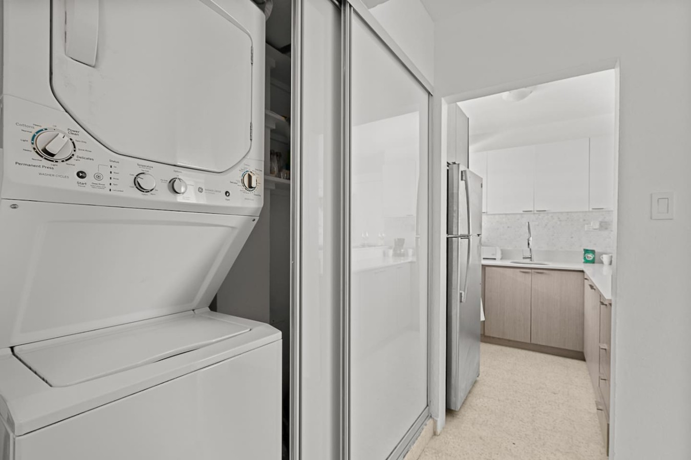Laundry nook with a stacked washer and dryer — Ocean Park 2BR Backyard BBQ Walk to Beach, Santurce