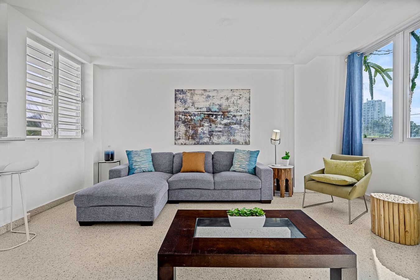 Living room with a couch and a painting on the wall — Ocean Park 2BR · Steps to Beach & Dining, Santurce