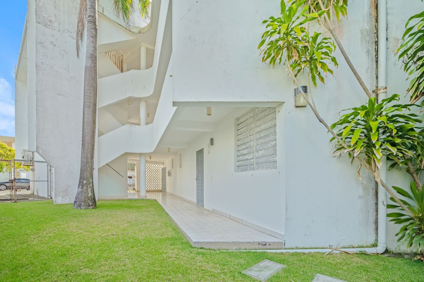 White building with a staircase leading to a balcony — Ocean Park 2BR · Steps to Beach & Dining, Santurce