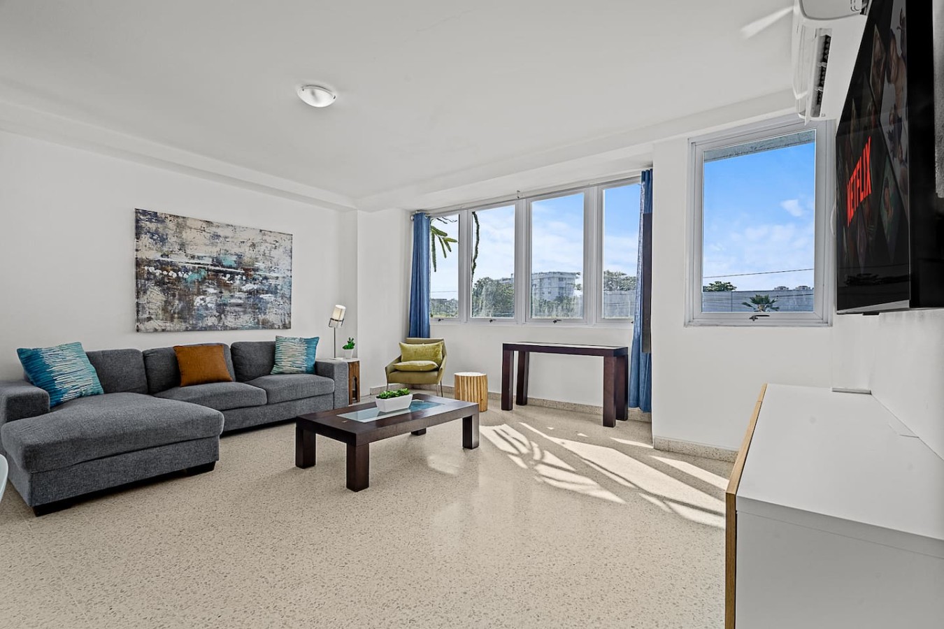 Living room with a couch, coffee table, and a view of the ocean — Ocean Park 2BR · Steps to Beach & Dining, Santurce