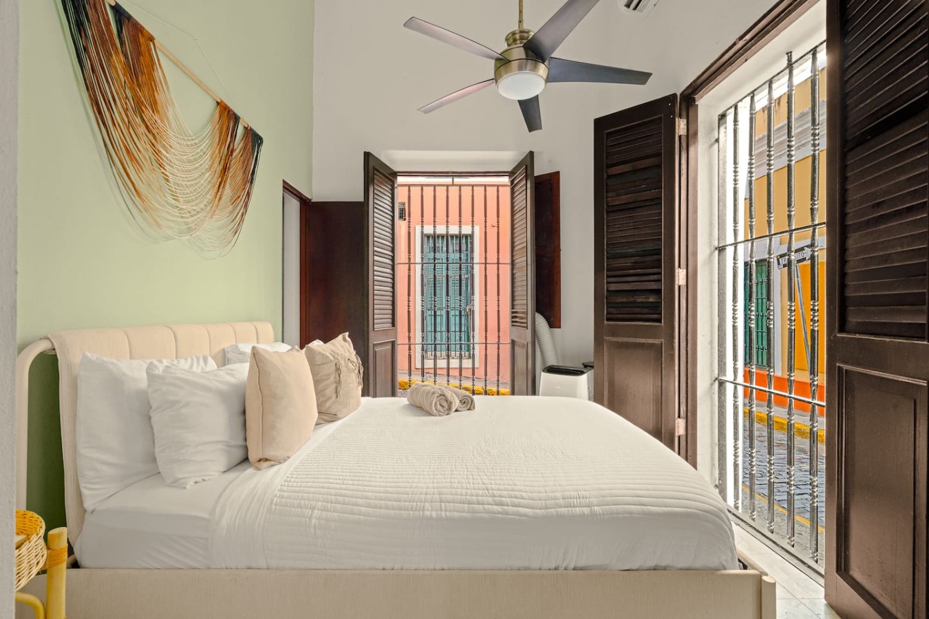 Bedroom with a white bed and a view of the street through the window — 3B Imperial, Old San Juan