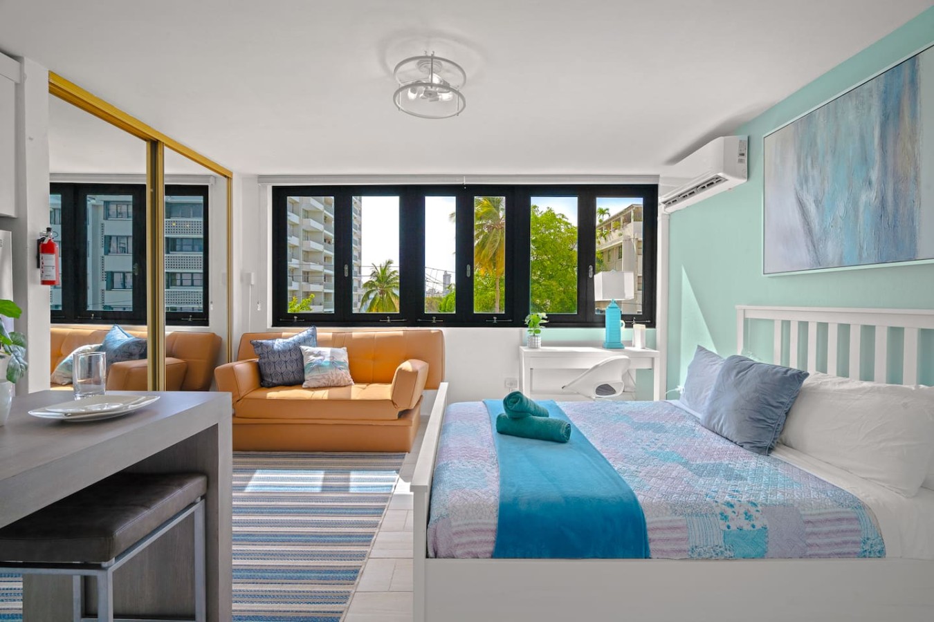 Bedroom with a blue bedspread and a view of the ocean — Casa Celeste | Sunlit Tropical Stay in Condado, Santurce
