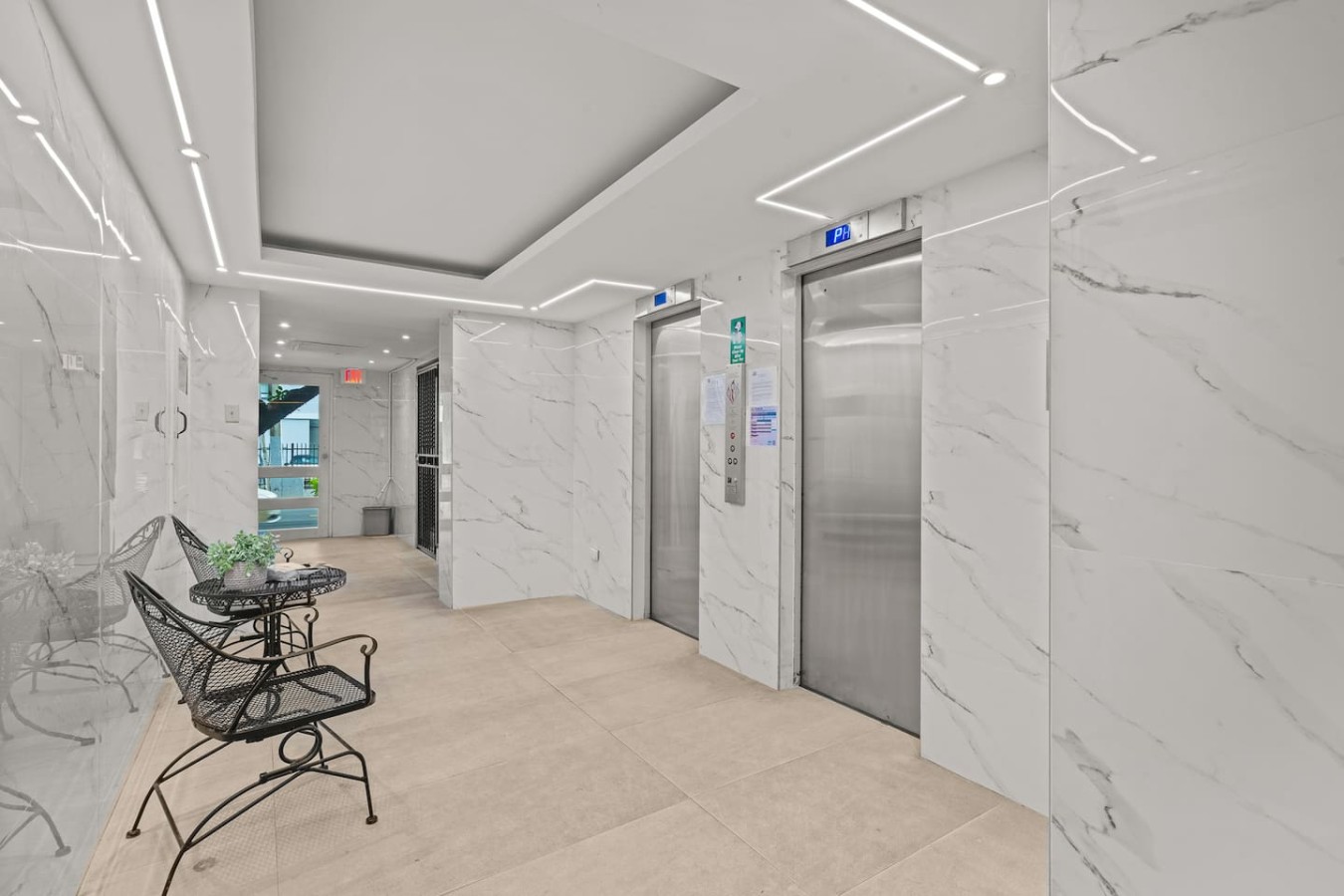 Building lobby with marble walls and elevators — Casa Celeste | Sunlit Tropical Stay in Condado, Santurce