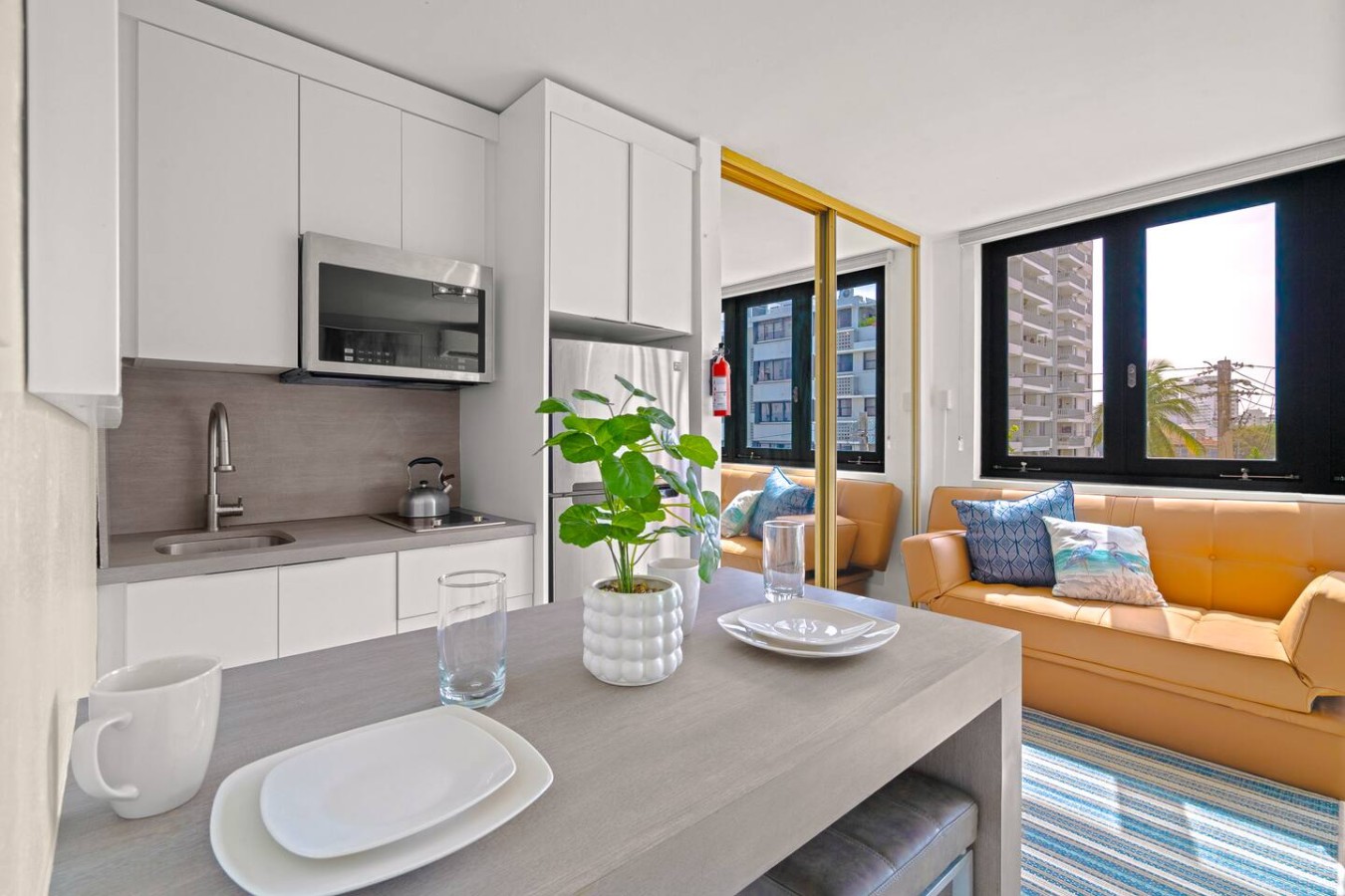 Kitchen with a microwave and a potted plant on the counter — Casa Celeste | Sunlit Tropical Stay in Condado, Santurce