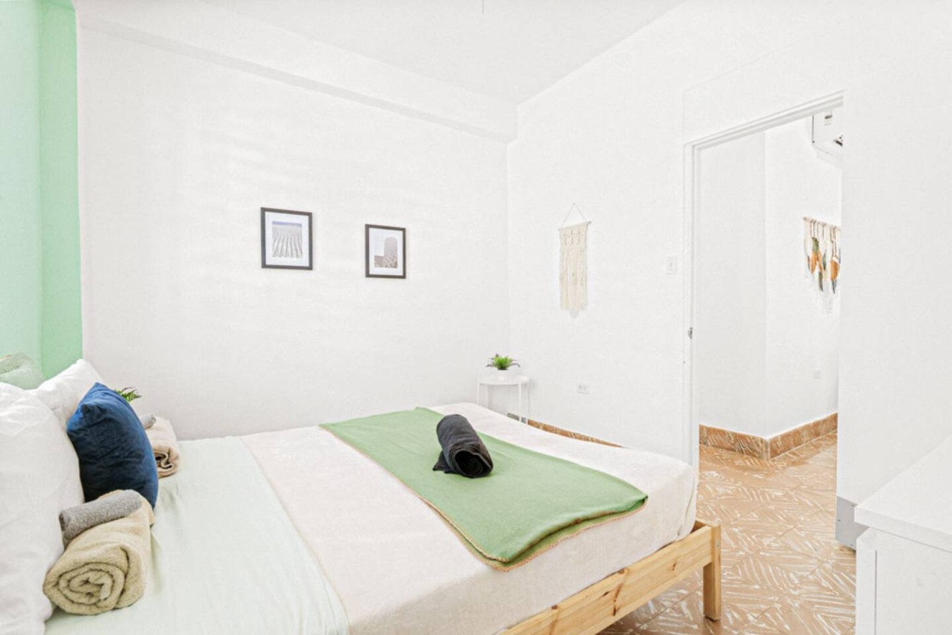 Bedroom with a bed and a green blanket on it — Virelia | Colorful San Juan Escape for Four, Santurce