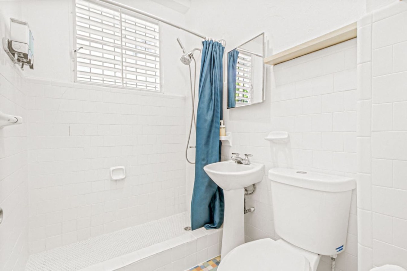 Bathroom with a blue shower curtain and white toilet — Virelia | Colorful San Juan Escape for Four, Santurce