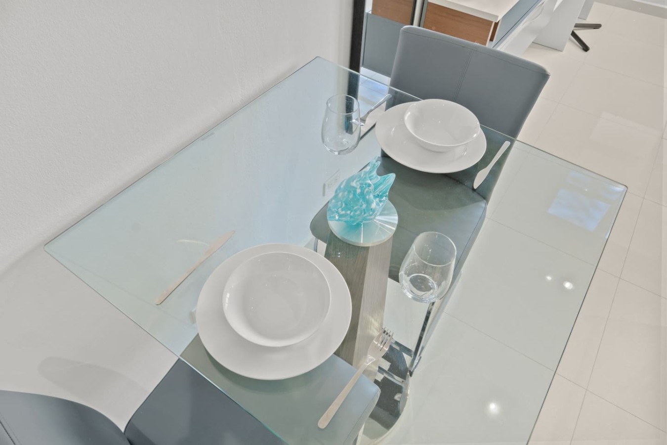 Table with two plates and two glasses on it — T-Mobile District San Juan Next to Beach, San Juan