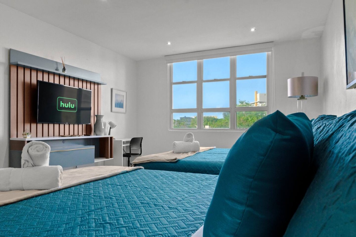 Bedroom with a blue bedspread and a view of the city — T-Mobile District San Juan Next to Beach, San Juan