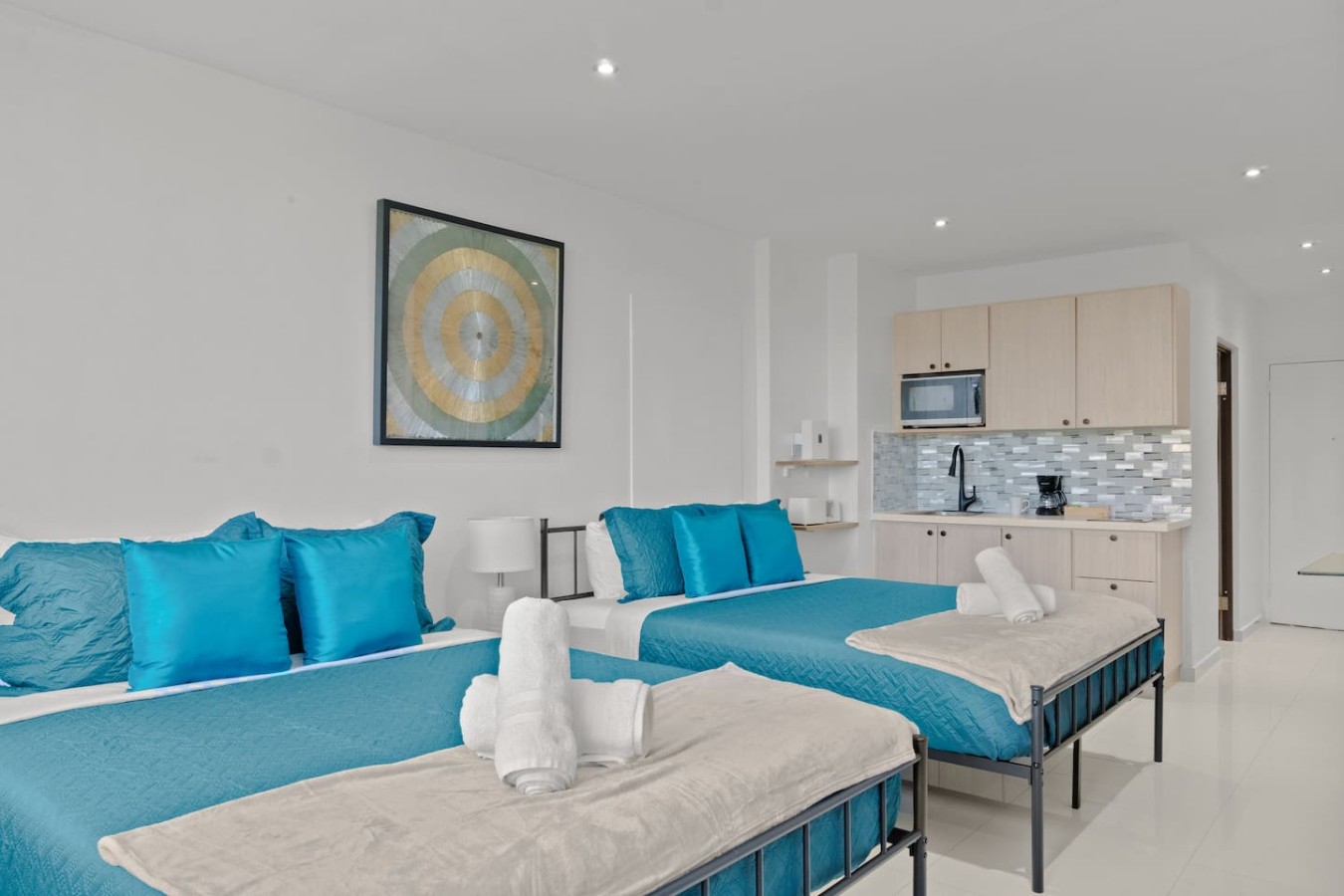 Two blue beds with blue pillows and blue sheets in a bedroom — T-Mobile District San Juan Next to Beach, San Juan