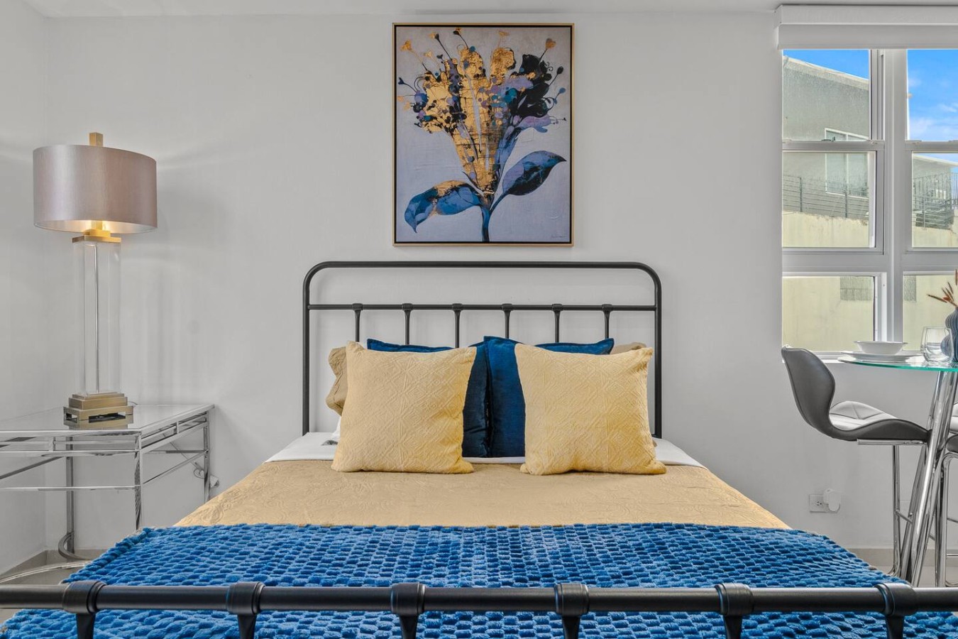 Bedroom with a blue bedspread and a painting on the wall — Caribbean Sea View | Tmobile District Free Parking, San Juan