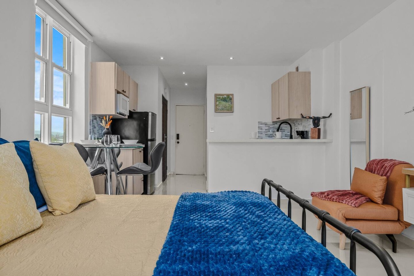 Bedroom with a blue blanket on the bed and a chair in front — Caribbean Sea View | Tmobile District Free Parking, San Juan
