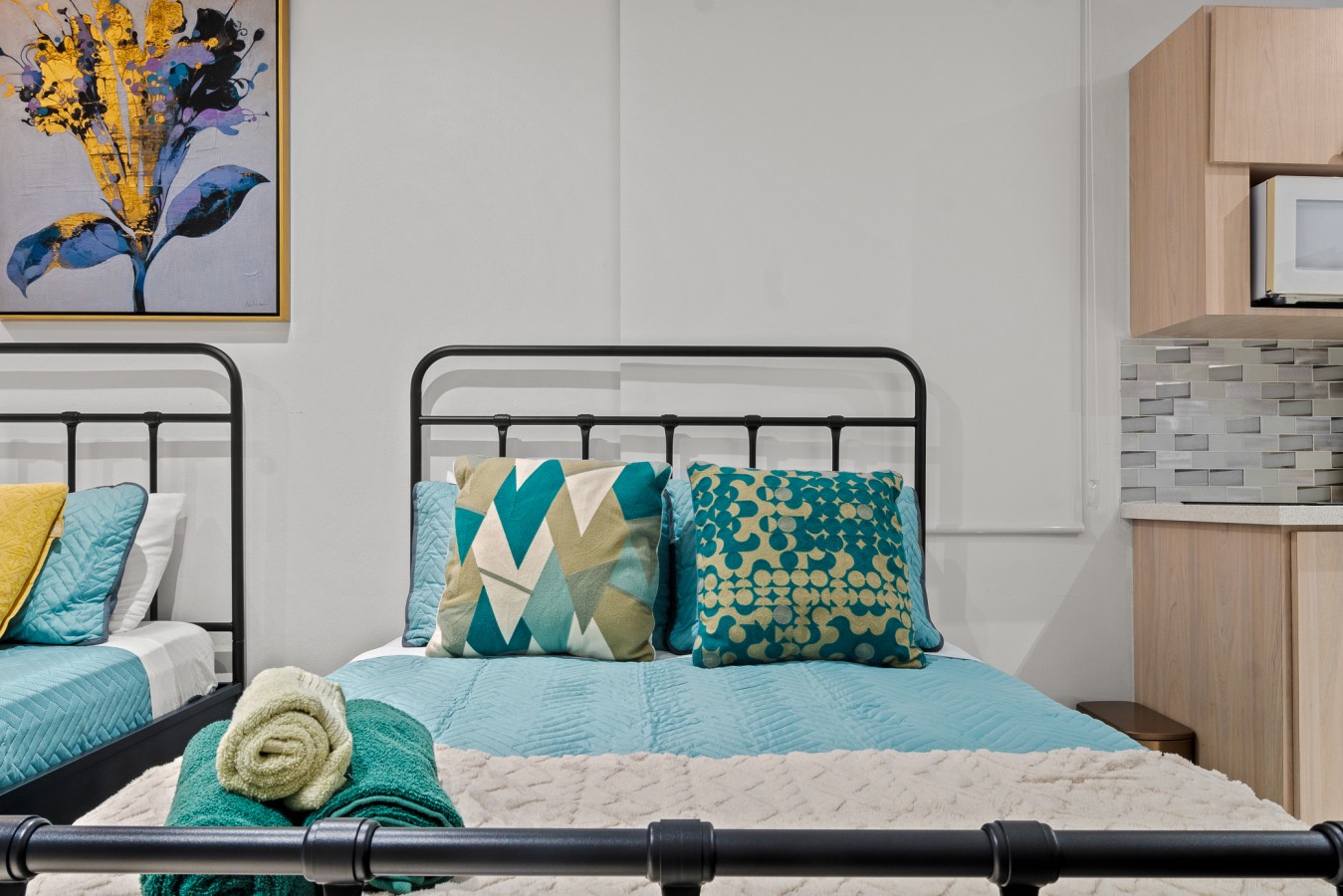 Bedroom with a black metal bed frame and two colorful pillows — Caribbean Sea View | Tmobile District Free Parking, San Juan