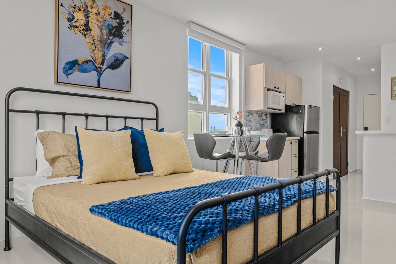 Bedroom with a blue bedspread and yellow pillows — Caribbean Sea View | Tmobile District Free Parking, San Juan
