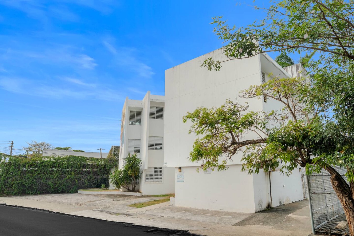 White building with a balcony and a tree in front of it — Private Patio 2BR Near Ocean Park Beach, Santurce