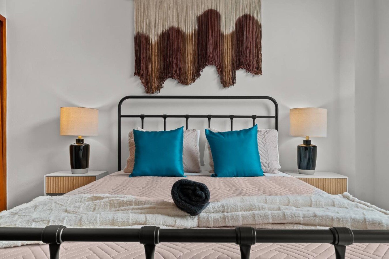 Bedroom with a black metal headboard and two blue pillows — Grand Galleria — Old San Juan Private Patio, Old San Juan