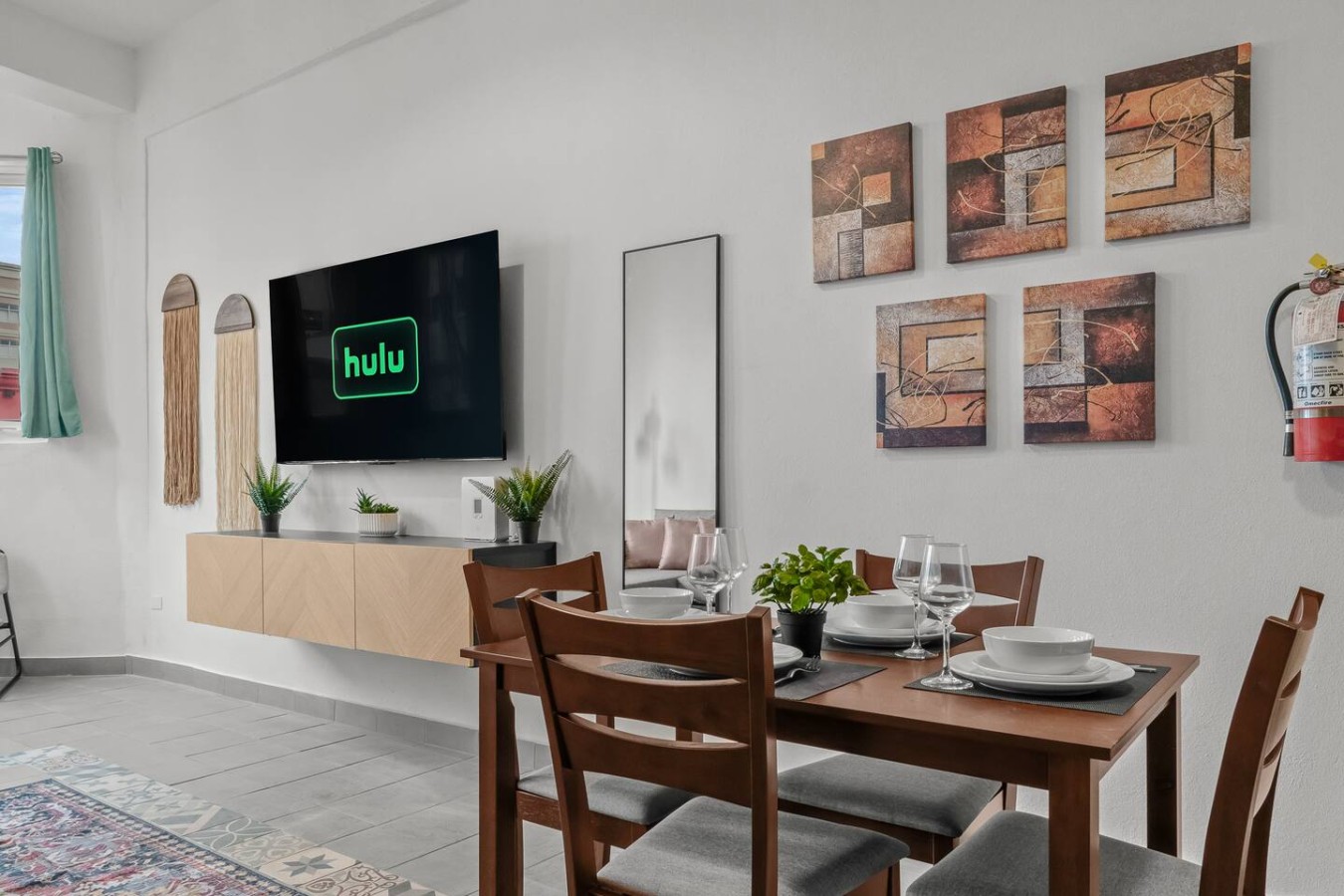 Dining room table with chairs and a TV in the background — Casa Valencia | Old San Juan, Old San Juan