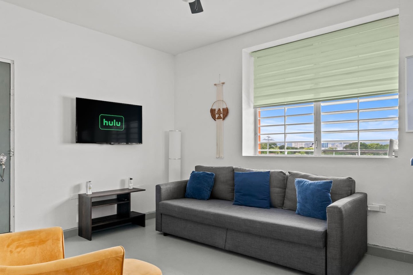 Grey couch in a living room with a flat screen TV on the wall — Santurce Blue 2BR | Near Beach & La Placita