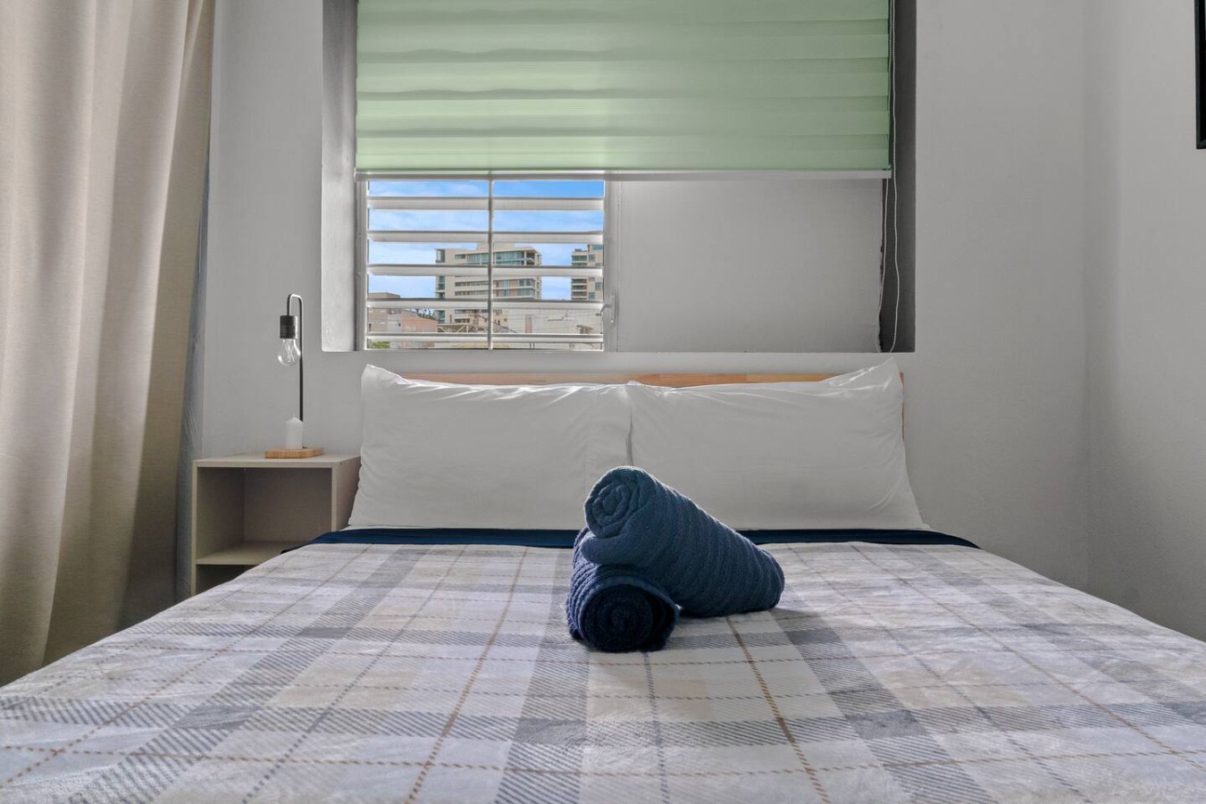 Bedroom with a bed and a blue towel on it — Santurce Blue 2BR | Near Beach & La Placita
