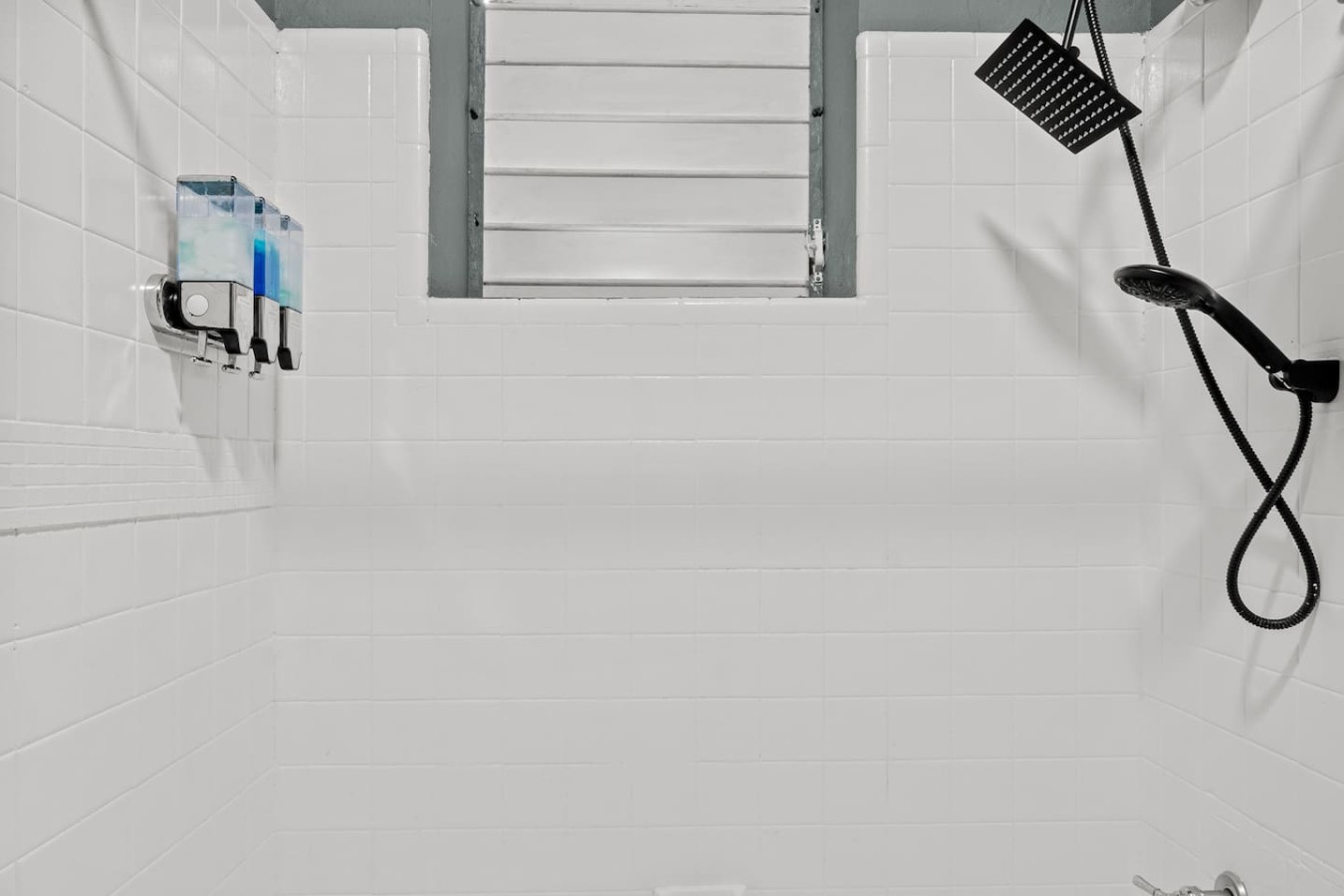 White tiled bathroom with a window above the shower — Santurce Blue 2BR | Near Beach & La Placita