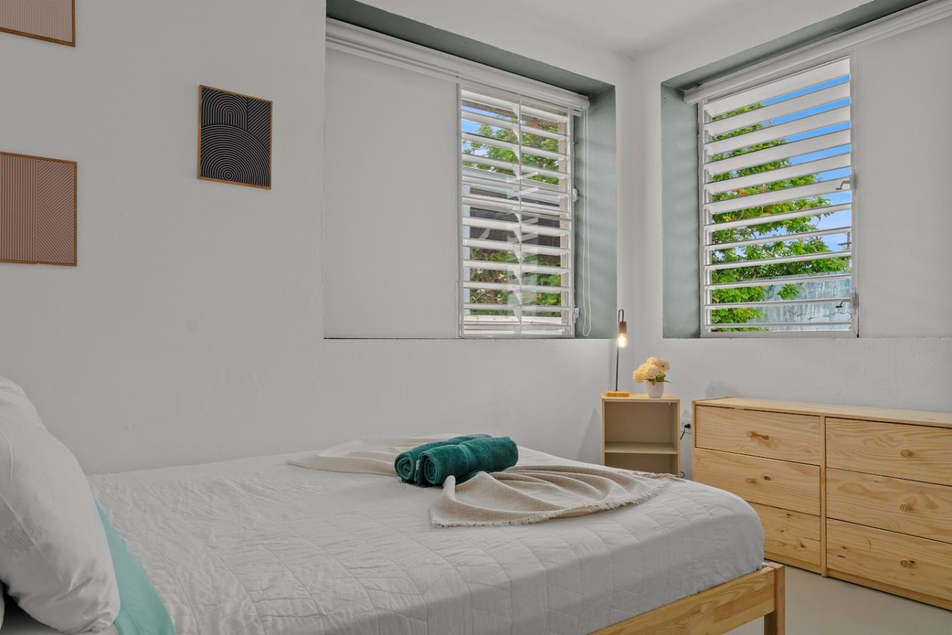 Bedroom with a white bedspread and a green towel on it — Santurce Blue 2BR | Near Beach & La Placita