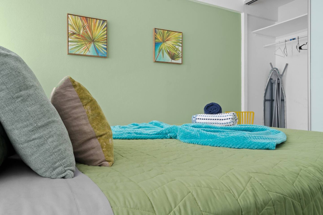 Bedroom with a green wall and a blue blanket on the bed — Maré 2BR | Near Ocean Park Beach + Laundry, Santurce