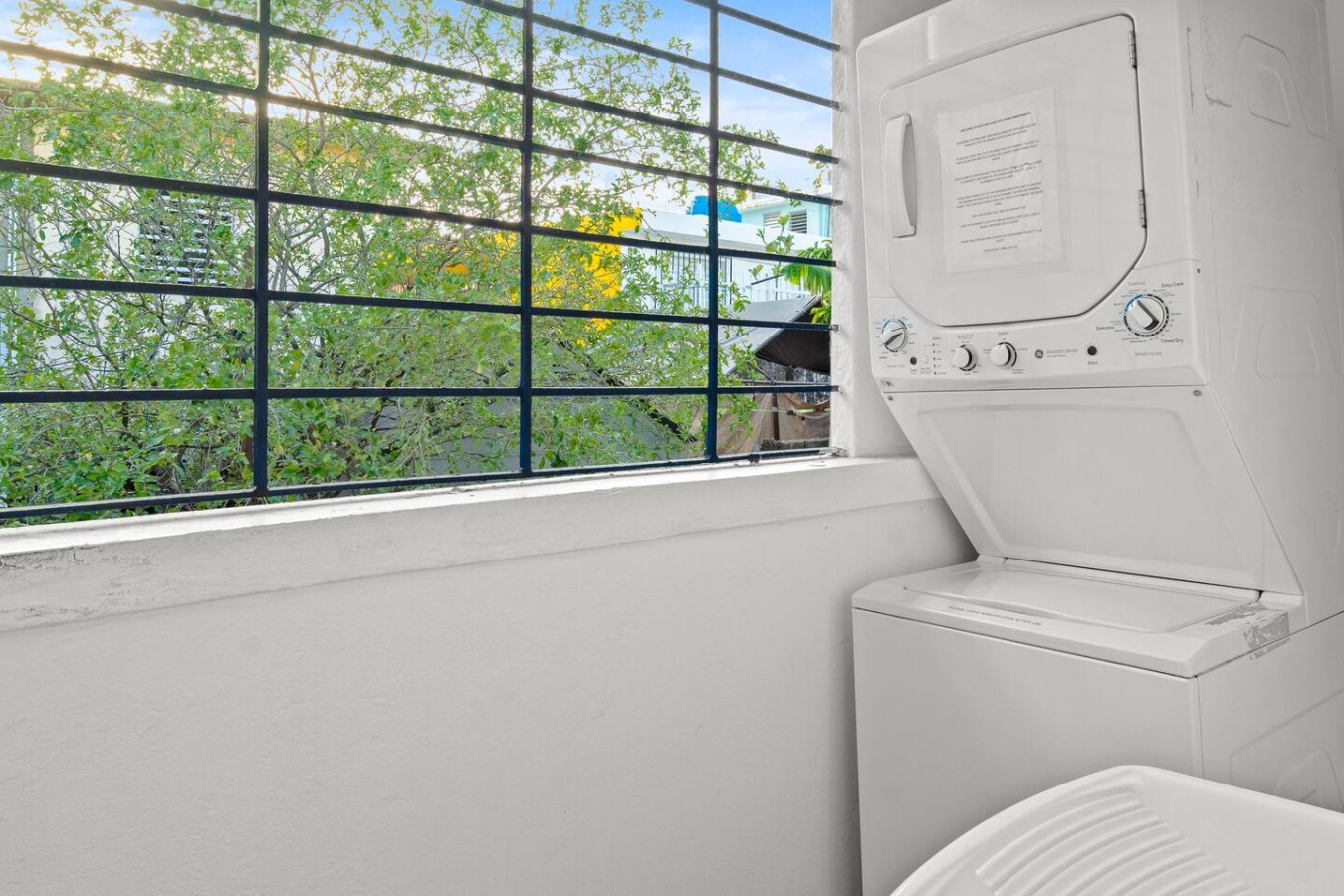 Stacked washer and dryer beside a window — Aurelia | Three Bedrooms in the Heart of San Juan, Santurce
