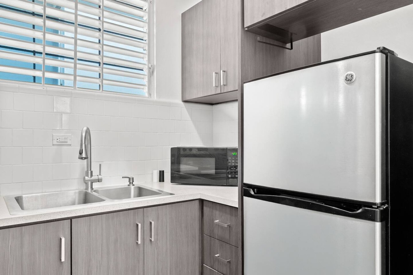Kitchen with a refrigerator, a microwave and a double sink — Aurelia | Three Bedrooms in the Heart of San Juan, Santurce