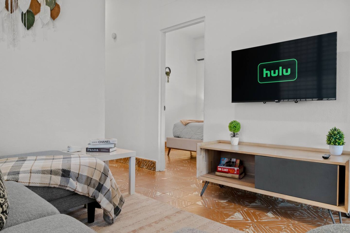 Living room with a wall-mounted TV and a wooden media console — Aurelia | Three Bedrooms in the Heart of San Juan, Santurce
