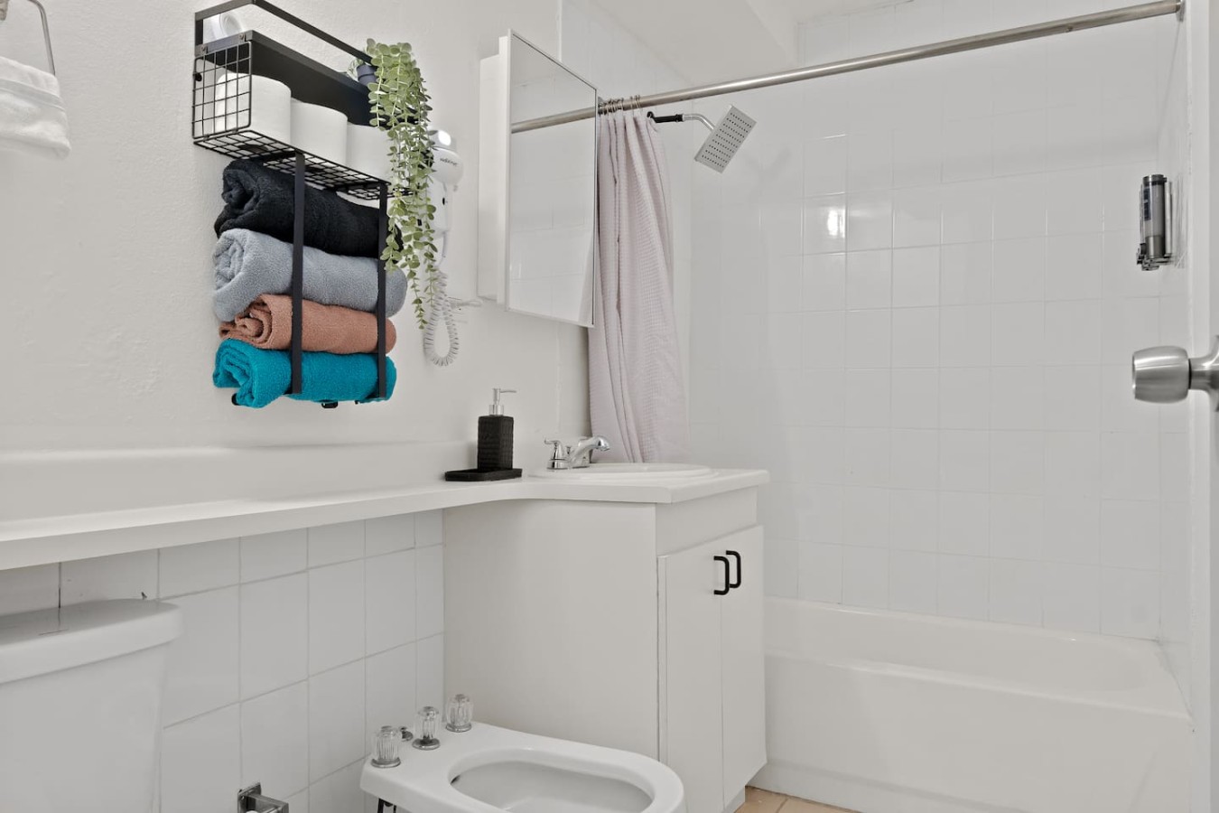 White bathroom with a toilet and a sink — The Castillo | Sleeps 8 | 2BR + Backyard & Parking, Santurce