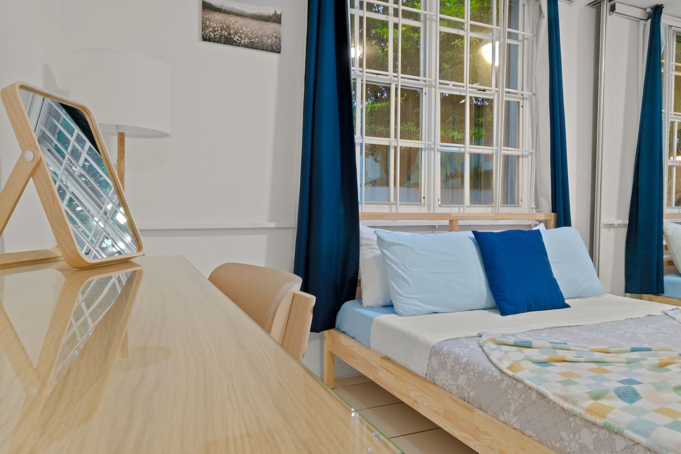 Bedroom with a blue bedspread and a window with curtains — The Castillo | Sleeps 8 | 2BR + Backyard & Parking, Santurce