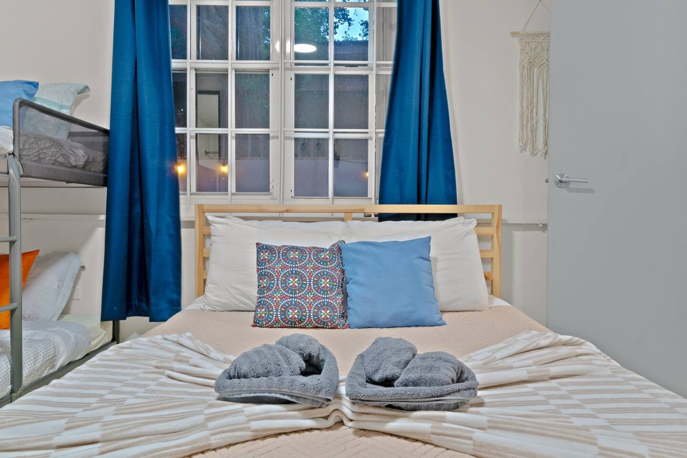 Bedroom with a bed, two pillows, and a window with curtains — The Castillo | Sleeps 8 | 2BR + Backyard & Parking, Santurce