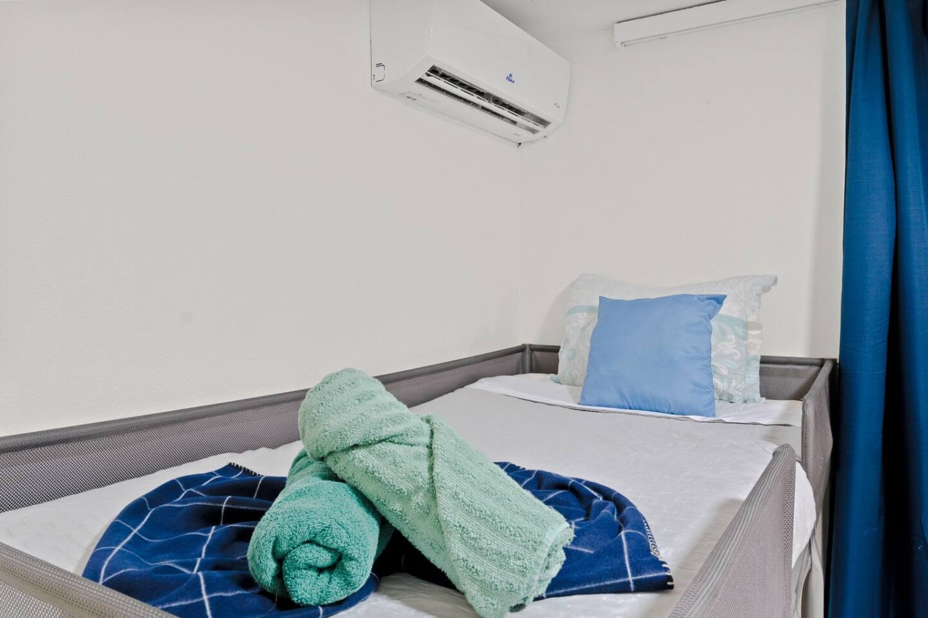 Bedroom with a bed and a green towel on it — The Castillo | Sleeps 8 | 2BR + Backyard & Parking, Santurce